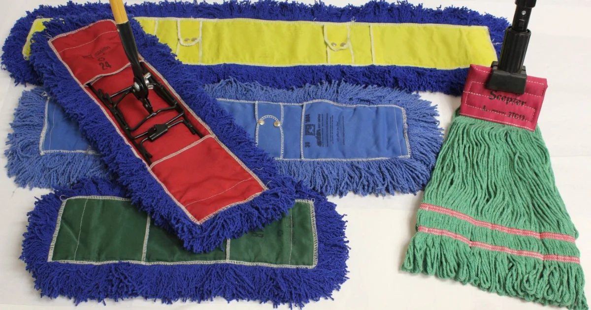 Assorted treated mop heads in different colors and sizes laid out, including red, blue, green, yellow, and a green string mop